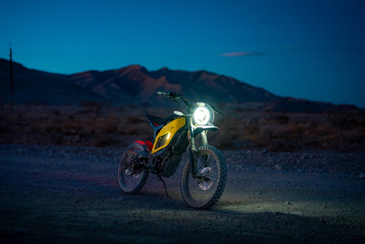 Electric motorbike lit against a dusk landscape